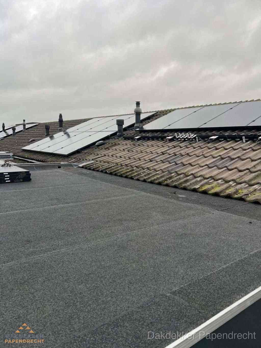 Plat dak inspectie met bitumen bedekking naast schuin pannendak in Papendrecht