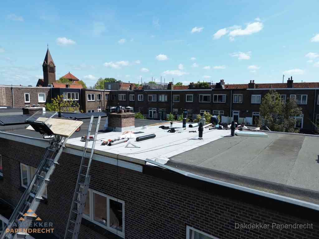 Dakdekkers aan het werk op plat dak in Papendrecht