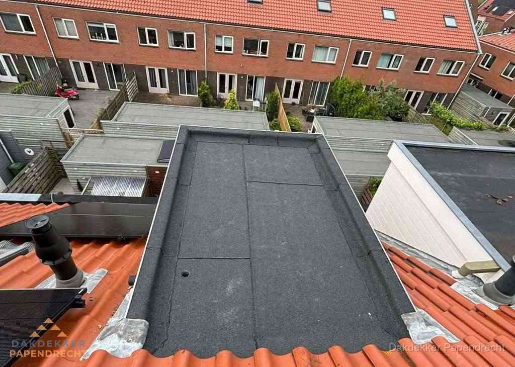 Plat dak met bitumen bedekking naast dakkapel in Papendrecht