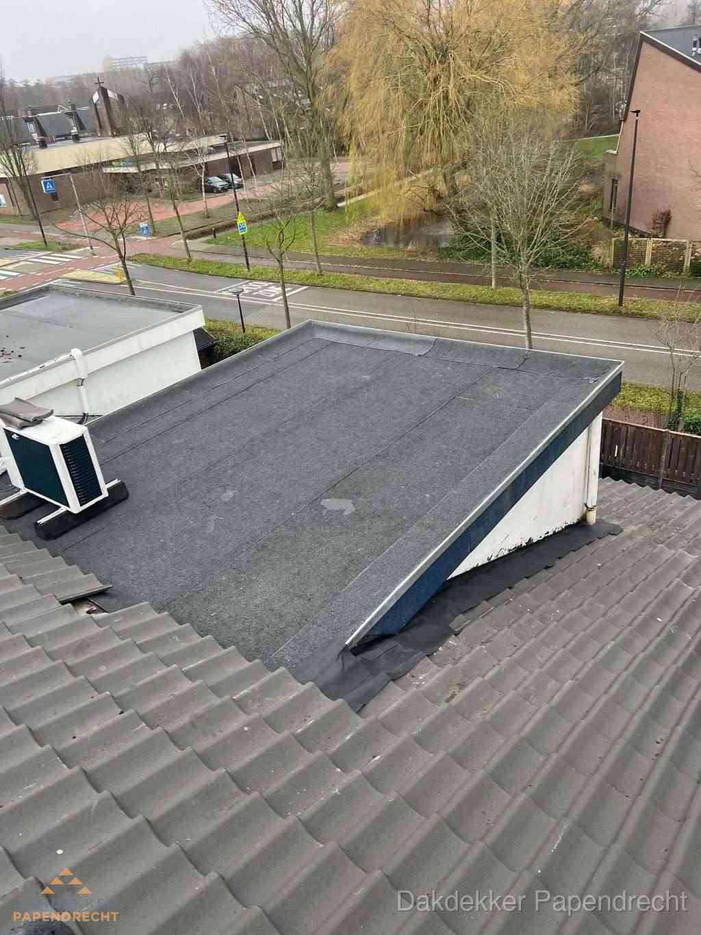 Plat dak met bitumen dakbedekking naast schuin pannendak in Papendrecht