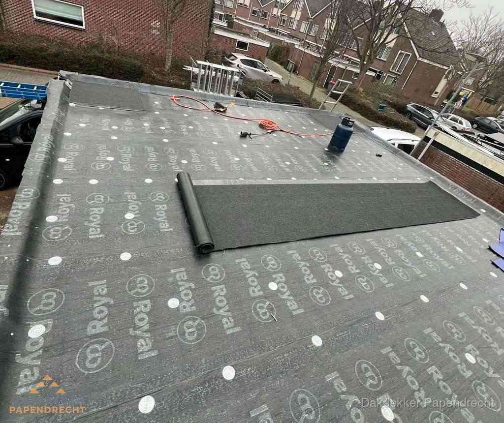 Dakdekker aan het werk met gasbrander op plat bitumen dak in Papendrecht